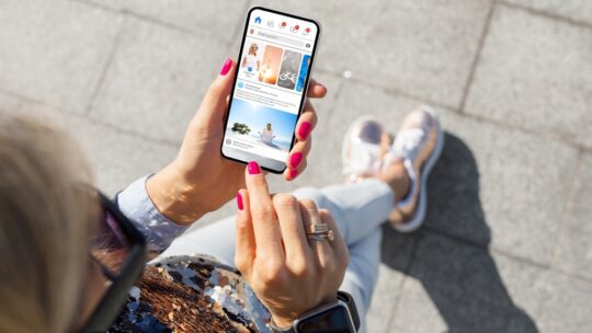 Woman using social media app to read news on mobile phone